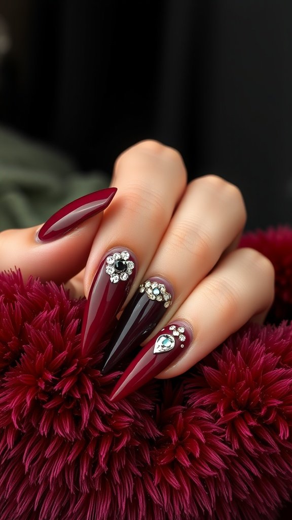 Close-up of cherry wine nails adorned with rhinestones on a textured background.