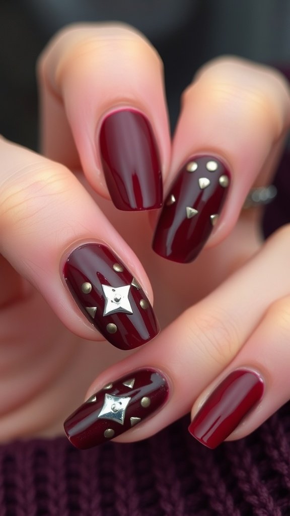 Glossy cherry wine nails with metallic studs in a stylish design